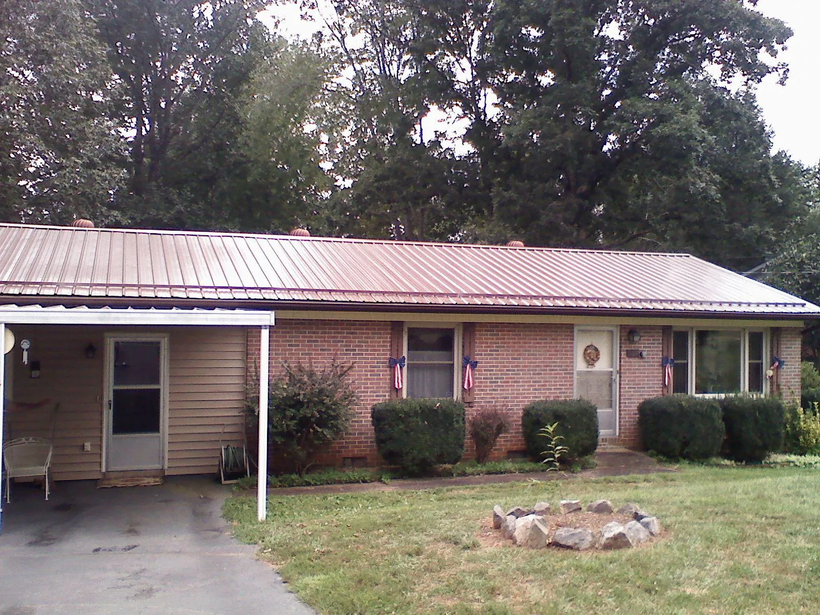Bronze metal roof and carport on a brick ranch home — Roof Repair work by our crew in Rockford